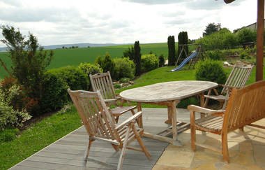 Terrasse mit Tisch und vier Stühlen, im Hintergrund auf der Wiese sieht man eine Rutsche | © Neckar-Zaber-Tourismus e.V.