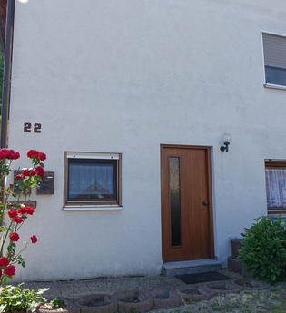 Außenansicht der Ferienwohnung: weißes Gebäude mit Fenstern und Holztüre | © Neckar-Zaber-Tourismus e.V.