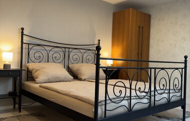 Schlafzimmer mit Metallbett, Nachtischen mit Lampen | © Block