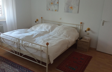 Schlafzimmer mit Metallbett und weißer Bettwäsche | © Dörr