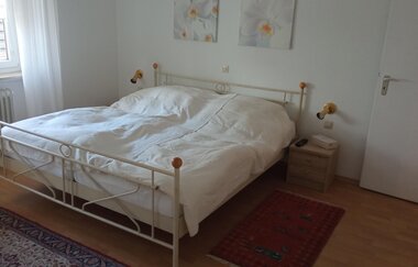 Schlafzimmer mit Metallbett und weißer Bettwäsche | © Dörr