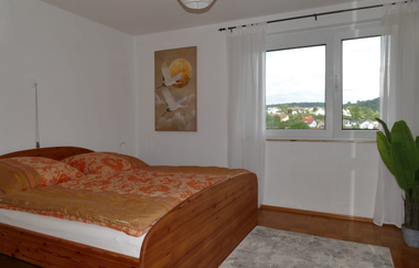 Schlafzimmer mit Holzbett und Teppich | © Hopf