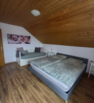 Zimmer mit Doppelbett und einer Couch und zwei Nachttischschränken | © Neckar-Zaber-Tourismus e.V.