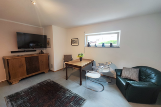 Zimmer mit Sofa, Esstisch, Stühlen und Kommode | © Lutz