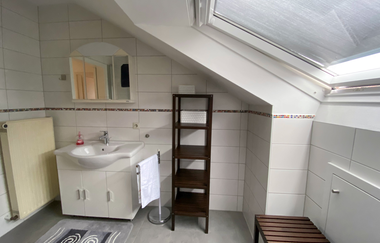 Badezimmer mit Waschbecken und Spiegel und ein hohes dunkles Regal | © Neckar-Zaber-Tourismus e.V.