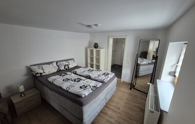 Schlafzimmer mit Holzboden, Standspiegel und Boxspringbett | © Wolf
