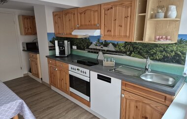 Küchenzeile mit Holzfront und Hinterwand mit Strandmotiv | © Wolf