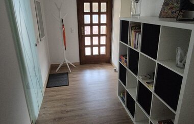 Flur mit Blick zur Haustür, offenes Regal an der Wand | © Wolf