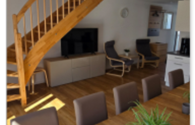 Essbereich der großen Ferienwohnung mit großem Tisch, Stühlen und im Hintergrund einer Treppe in den zweite Etage | © Landgut Schellenbauer