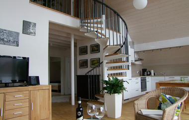 Blick auf das Wohnzimmer mit Fernseher und tisch und Stuhl, die Küche im Hintergrund | © Neckar-Zaber-Tourismus e.V.