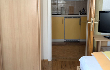 Zimmer mit Schrank und Bett,  Tür zur Küche | © Bauer-Thorpe