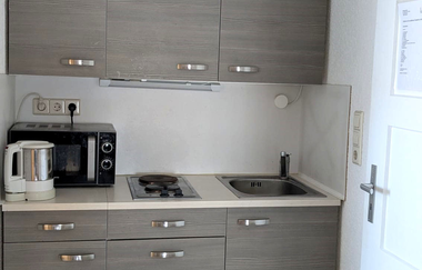 Moderne kleine Küchenzeile in grau und weiß | © Bauer-Thorpe