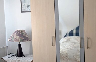 Schrank mit Spiegel und Tischchen mit Lampe | © Bauer-Thorpe