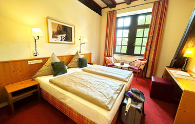 Innenansicht eines Zimmers in der Herzogskelter: Zimmer mit Doppelbett und rotem Teppich | © Herzogskelter Güglingen