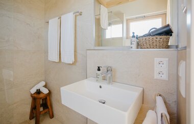 Waschbecken mit Wandspiegel, Handtüchern und Badutensilien | © Weingut Becker, Malsch