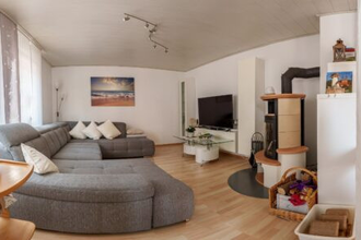 Wohnbereich mit großer grauer Couch, einem Flachbildfernseher und einem Kamin | © Neckar-Zaber-Tourismus e.V.