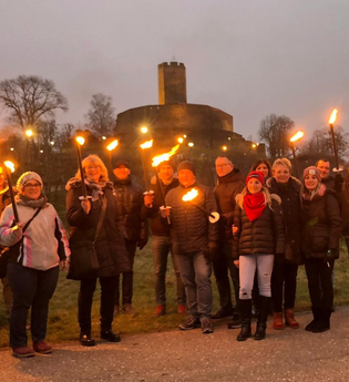 Menschen mit Fackeln vor der Burg Steinsberg