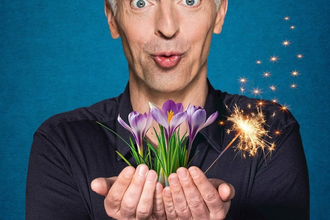 Künstler hält einen Strauß Krokusse sowie eine Wunderkerze in der Hand