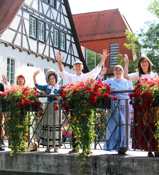 Gruppe Stadtführer stehen winkend auf einer Brücke