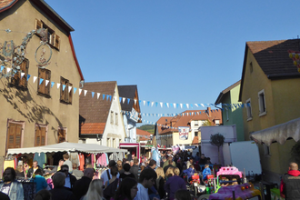 Viele Menschen bummeln durch die Rauenberger Innenstadt, zwischen den Häusern spannen Girlanden und an den Straßenrändern reihen sich links und rechts Imbissbuden und Verkaufszelte | © Landratsamt Rhein-Neckar-Kreis