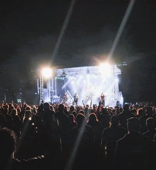 Menschenmenge vor einer Konzertbühne bei Nacht