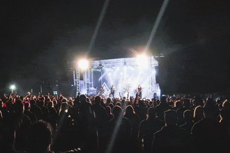 Menschenmenge vor einer Konzertbühne bei Nacht