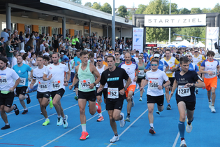 Gruppe von Läufern beim Start auf einer blauen Tartanbahn