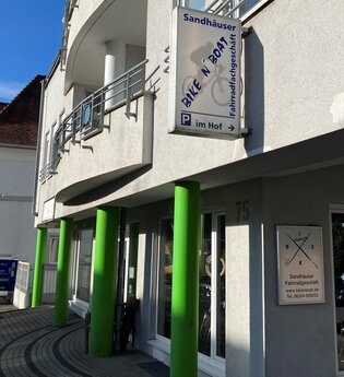 Außenansicht des Fahrradgeschäfts mit grünen Säulen