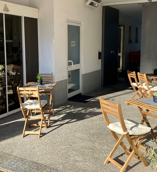 Eingang und Außenbereich mit Sitzmöglichkeiten und Tischen