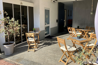 Eingang und Außenbereich mit Sitzmöglichkeiten und Tischen