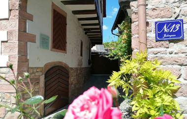 Über eine Rose im Vordergrund sieht man in eine dunkle Niesche in der einst der Turm stand. | © Stadt Weinheim - Jasmin Wolf