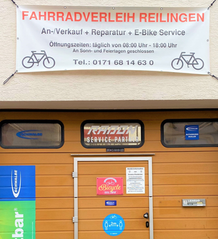 Eingangstor zum Fahrradverleih mit verschiedenen Informationsbannern