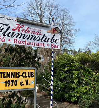 Schild der Flammstube vor den Tennisplätzen