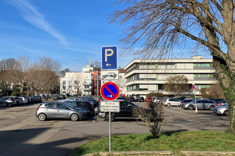 Parkplätze vor Gebäuden und Schildern im Vordergrund