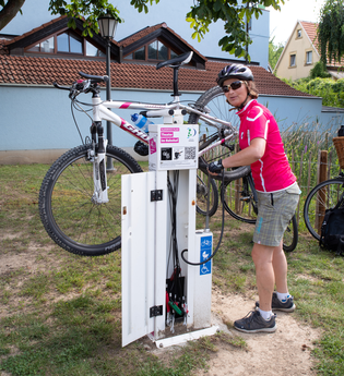 Radfahrerin an einer Rad Service Station mit einem aufgehängten Rad, um die Reifen aufzupumpen. | © Landratsamt Rhein-Neckar-Kreis