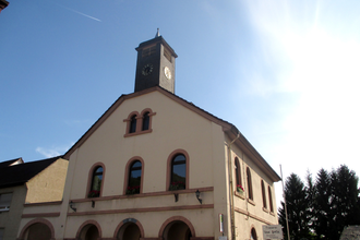 Gebäude mit Glockenturm vor blauem Himmel | © Maria Zimmermann