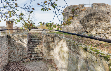 Ein Innenhof von hohen Mauern umgeben und mit Eichenblättern bedeckt im Herbst. | © Petra Arnold
