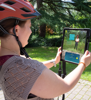 Frau die ein Tablet hält und die Augmented Reality App Weitersehen nutzt