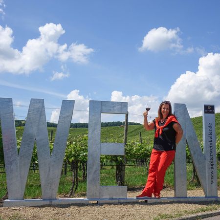 Frau lehnt mit Rotweinglas im WEIN-Fotospot