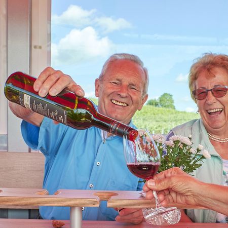 Mann im Planwagen schenkt Rotwein ein